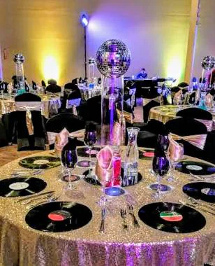 Mesa con centro de esfera disco, discos de vinilo y mantel dorado